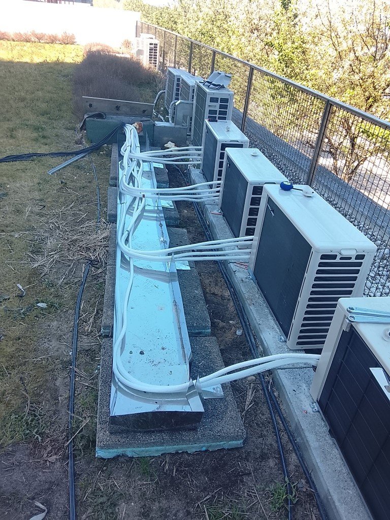 Instalação profissional de várias unidades condensadoras com calha de proteção